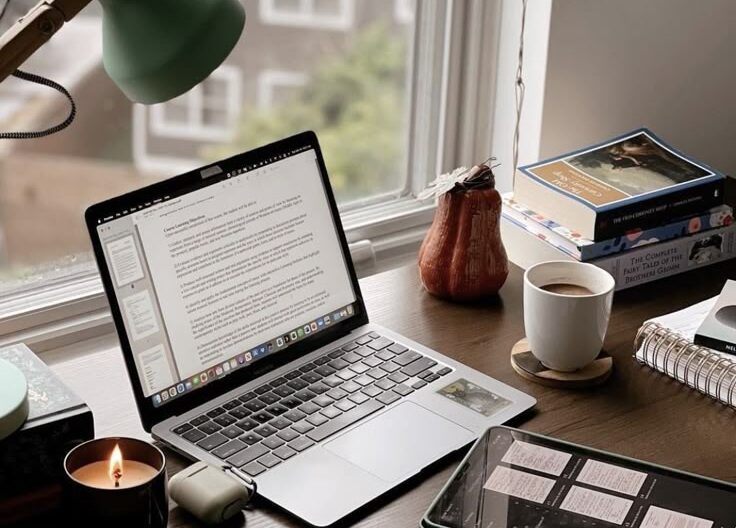 Mesa de trabalho com um computador, um ipad e café